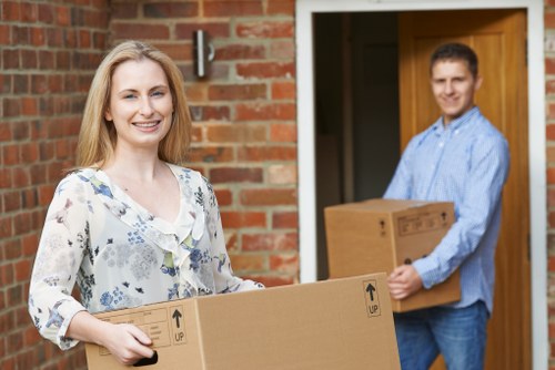 Movers carrying household items from a Finchley property